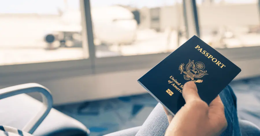 An airport traveler with a US Passport in their hand