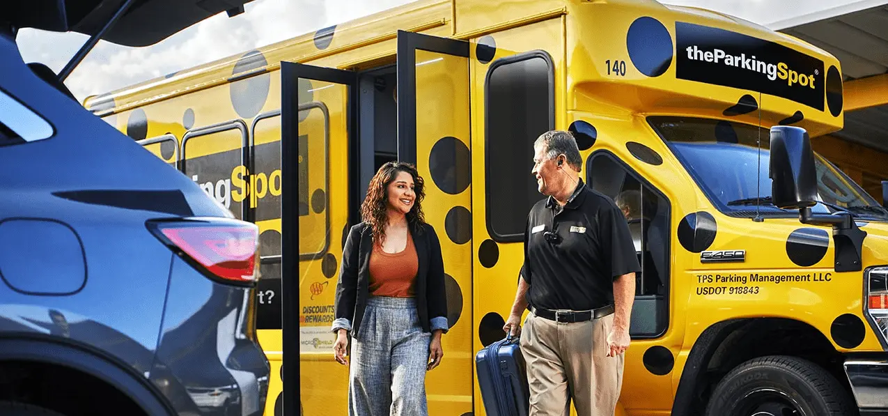 Airport shuttle driver helps a guest of The Parking Spot with his bags.