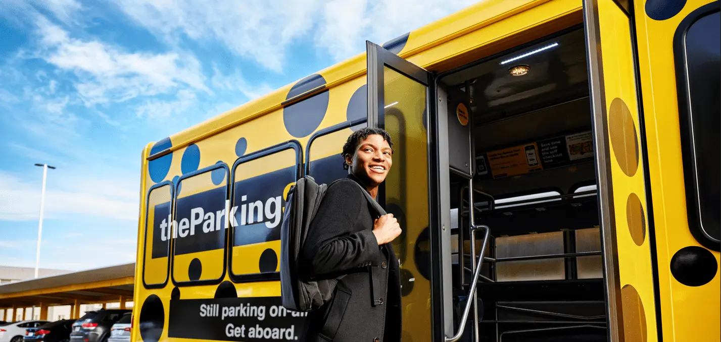 Airport shuttle driver helps a guest of The Parking Spot with his bags.